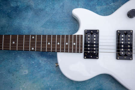 Beautiful vintage white electric guitar shape on a blue background. High quality photoの写真素材