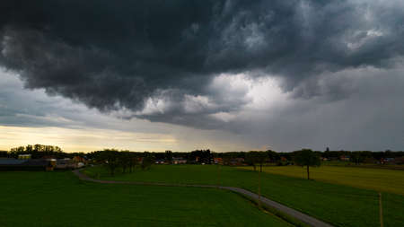 Aerial landscape of countryside with colorful storm clouds. Extreme thunderstorm over a farm and agricultural fields and road. High quality photoの写真素材
