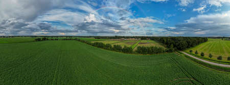 Aerial panorama view shot with drone of a rainbow over stormy sky. Rural landscape with rainbow over...