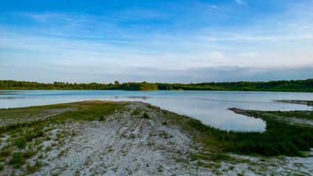 Beautiful view of nature landscape on sunny summer day. Green tall trees on lake coast line. Beautiful nature backgrounds. High quality photoの写真素材
