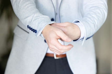 Close up image of a fashion the hands of a young businessman, handsome model man in casual cloth costume. Wearing the vest in the cage, black jeans and blue shirt. High quality photoの写真素材
