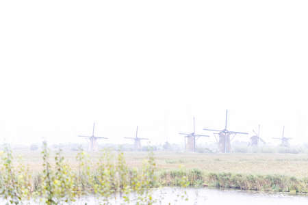 02-10-2021, Kinderdijk, The Netherlands, View of traditional windmills on a misty grey day in Kinderdijk, The Netherlands. . High quality photoのeditorial素材