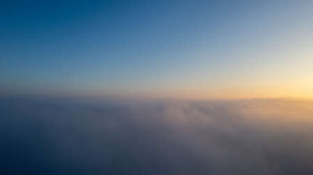 Aerial View. Flying in fog, fly in mist over the early morning clouds in the rising sun. Aerial...