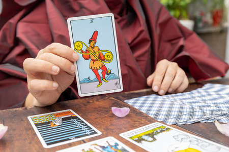 15th of september, 2021, Antwerp, Belgium, Magical scene, esoteric concept, fortune telling, woman showing a tarot card, tarot cards on a table. The concept of divination, astrology and esotericism, illustrative . High quality photoの写真素材