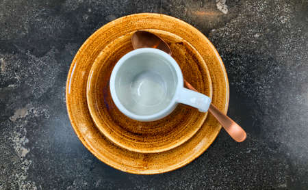 empty white coffee or tea cup on a brown saucer on dark table background. High quality photo