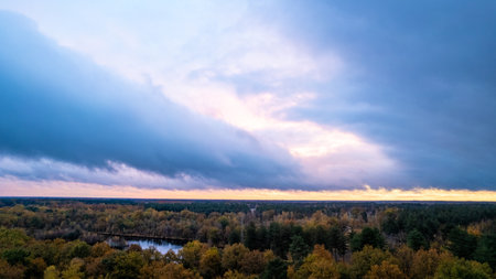 Moody sunset clouds over a forest in the fall. High quality photoの写真素材