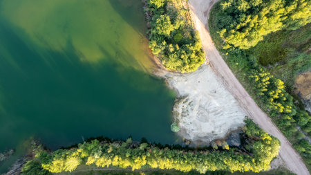 Aerial view over beautiful turquoise mountain lake and green forest. Spring in the mountains. Green forest, mountain lake. Green pine and fir trees forest and a lake. Beautiful mountain road. - Image. High quality photoの写真素材