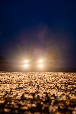 Yellow headlight and dirtroad in the dark after snowing. Car driving on a dangerous road in dire circumstances. High quality photoの写真素材