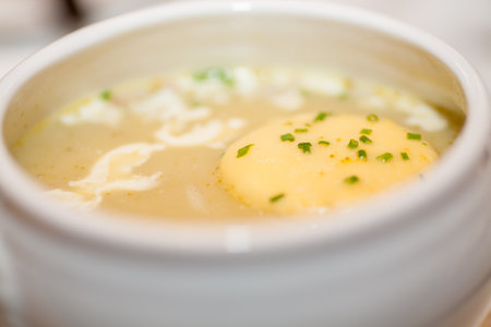 Indulge in the richness of this creamy soup, where flavors meld in perfect harmony. A delectable piece of butter gently floats on the surface, promising a luxurious culinary experience. Savory Delight: Creamy Soup with a Floating Butter. High quality photoの写真素材