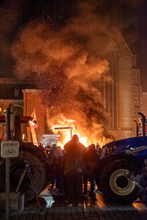 Turnhout, Antwerp, Belgium, 28th of January, 2024, This powerful image captures a moment of protest under the night sky in Turnhout, Belgium, where farmers have gathered to express their dissent against the Nitrogen Agreement. The burning embers and the dのeditorial素材