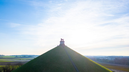 Waterloo, Brussels, Belgium, February 25th, 2024, This image portrays the Lion's Mound at the historic site of the Waterloo Battlefield under the expansive morning sky. The silhouette of the lion statue is set against the bright, clear sky with the sun beのeditorial素材
