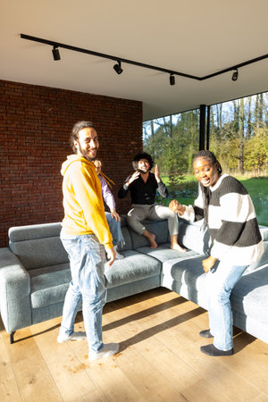 Four friends share a joyful moment in a modern living room, smiling and enjoying each others company...