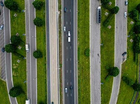 Aerial view of a modern highway surrounded by greenery, showcasing a vibrant urban ecosystem and...