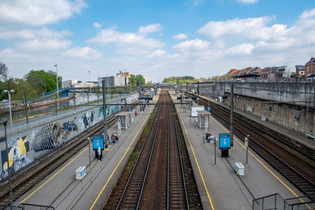 Halle, Belgium, May, 15th, 2024, The train station has multiple tracks and a blue sky in the background, illustrating urban design with a touch of nature and infrastructureのeditorial素材