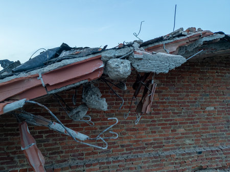 A damaged roof that is showcasing various debris and noticeable structural integrity loss due to...