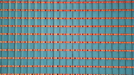 An intricate pattern of LED lights dominates this image, showcasing the precise matrix within a large agricultural greenhouse. The harmonious alignment of light strips with the blue-tinted panels reflects a dedication to efficient plant nurturing and futuristic farming practices. Architectural Harmony: A Matrix of LED Lights in an Agricultural Greenhouse. High quality photoの写真素材