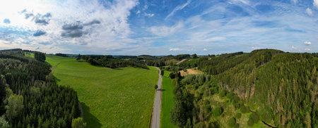 Belscher Aifel, Lengeler, Burg-Reuland, Liege, Belgium, 22nd of September, 2024, Aerial view showcases a breathtaking landscape of green fields, hills, and a winding road inviting explorationの写真素材