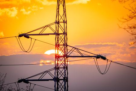 A stunning and breathtaking sunset beautifully highlights a towering pylon against a vibrant and...
