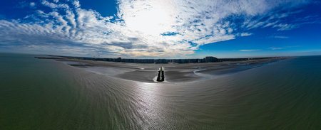 Nieuwpoort, Belgium, October 5th, 2024, An aweinspiring aerial photograph captures a peaceful coastal landscape lying beneath an expansive blue skyの写真素材