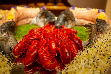 This vibrant seafood platter features an exquisite array of bright red crawfish alongside various fresh fish delicaciesの写真素材