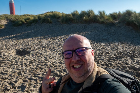 Eierland, De Cocksdorp, Texel, The Netherlands, Oktober 28th, 2024, I am enjoying a beautiful, sunny day at the beach while capturing wonderful memories with a lighthouse nearbyの写真素材