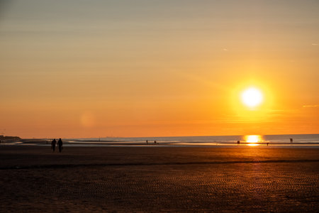 A tranquil beach sunset scene beautifully captures silenced figures framed against the stunning golden horizonの写真素材