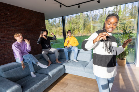 Group of friends enjoying digital content on smartphones in a modern living room with large windows.の写真素材
