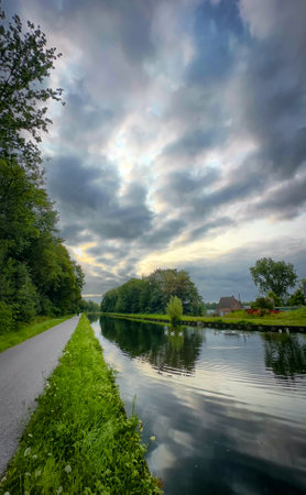 A serene canal scene reflecting vibrant skies and lush greenery, perfect for nature lovers to enjoy