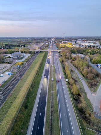 E19 Breda-Antwerp, Brecht, Antwerp, Belgium, April 8th, 2025, Aerial view of a highway intertwined with lush greenery and extensive urban infrastructure is breathtakingの写真素材