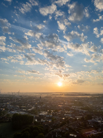 Bergensesteenweg, Sint-Pieters-Leeuw, Brussels, Belgium, 13th of May, 2025, A breathtaking view of the sunrise illuminating the city, with vibrant clouds and shimmering waters.の写真素材