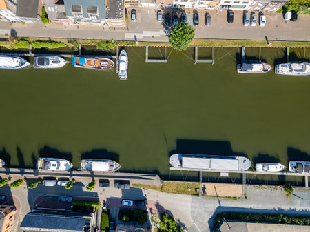 Klein-Willebroek, Willebroek, Antwerp, Belgium, 13th of May, 2025, This stunning aerial shot captures a serene scene of boats perfectly lined up on a peaceful green canalの写真素材