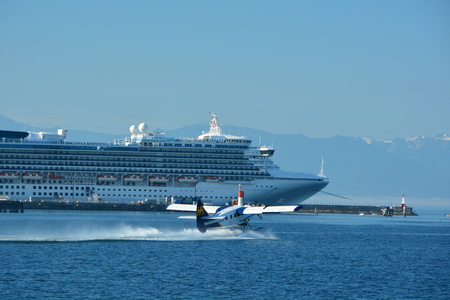 Float plane taking off from inner harbor in Victoria BC,Canada,while a cruise ship watchesのeditorial素材
