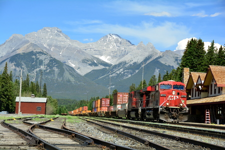 Banff Train depot.A cargo train goes through Banff National Park station to its destination.のeditorial素材