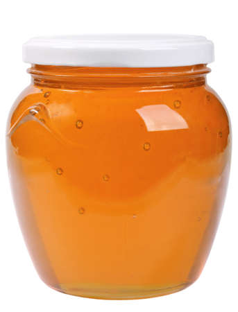 The only closed glass jar with honey. Isolated on white background.の写真素材