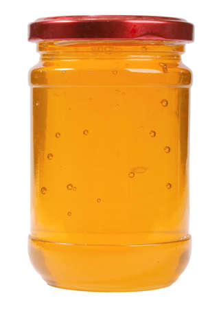 The only closed glass jar with honey. Isolated on white background. の写真素材