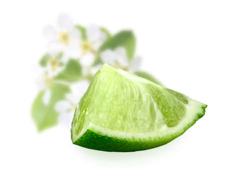 Part of fresh lime and of-focus green leaf an flowers on backdrop