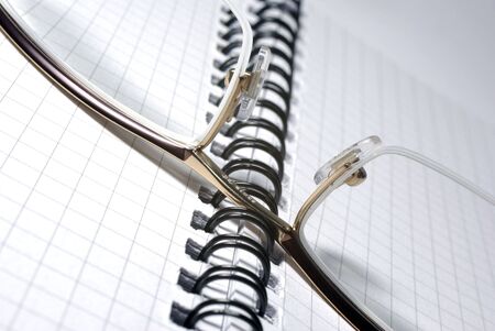 Glasses laying on spiral notebook. Office concept.の写真素材