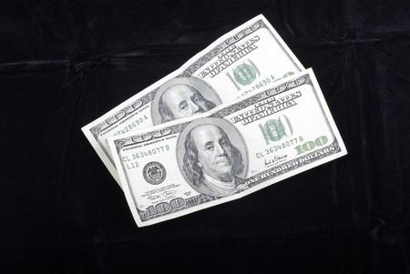 Two hundred dollars banknotes isolated on black velvet background.の写真素材