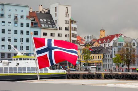 Harbor of the city of Bergen. Focus on norwegian flag. Summer scandinavian weather.の写真素材