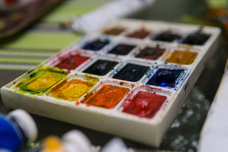 Art Palette with Colorful Paints Close Up View. Open Aquarelle Watercolor Palette at Art Studio Open Space. Artist Work Place with Main Painter Art Supplyの写真素材