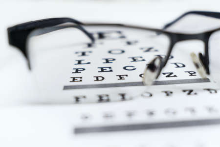 Glasses in the hands on the background of the table for vision