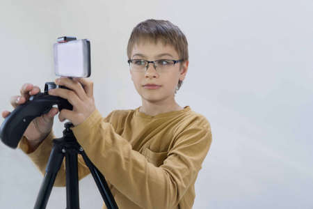 schoolboy generation Milenium stands at the concrete wall in his house and shoots video for his...