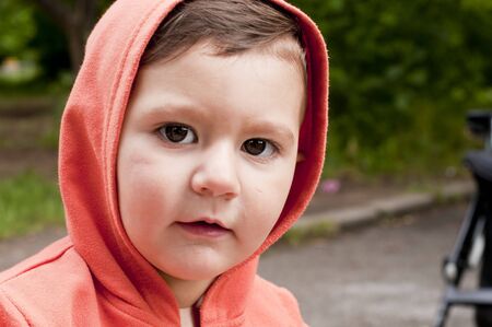 Baby with a hood and baby carriageの写真素材