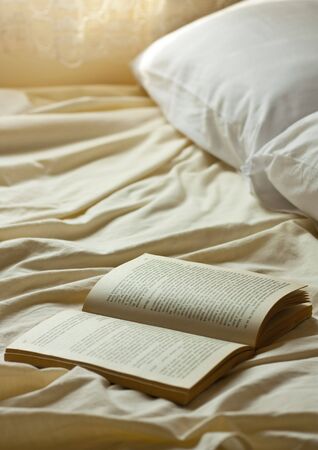 Open book on a empty bedの写真素材