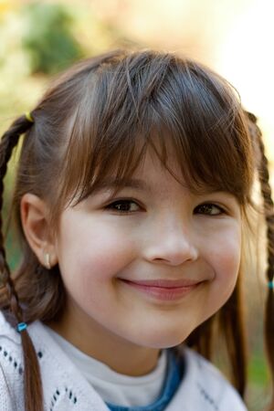 Portrait of cute smiling little girl enjoying the sun in the gardenの写真素材