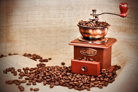 Contrast image of vintage  coffee  mill or grinder with coffee beans .Dramatic lightningの写真素材