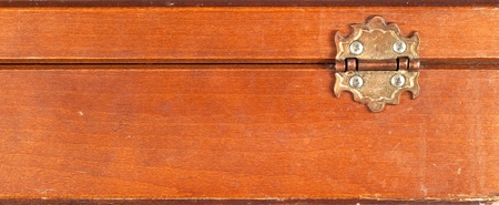 Close up of back of a vintage or retro wooden box showing hinge  