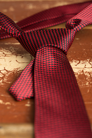 Red tie with Windsor knot on a old grunge suitcase as a background.Shallow DOFの写真素材