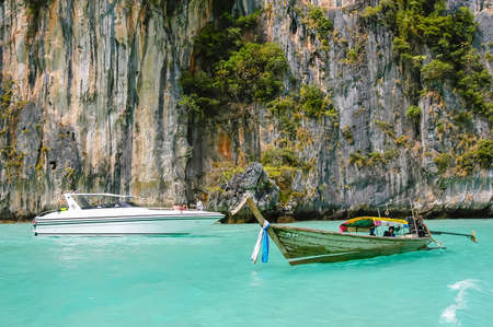Long-tail boat, speedboat, rocks and sea, Phi Phi island, Thailandの写真素材