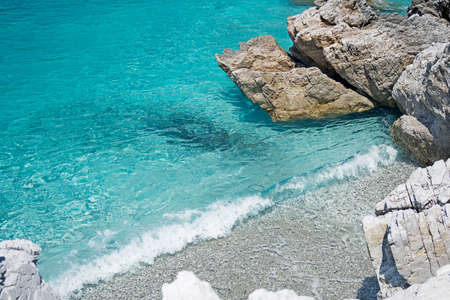 Beautiful clear, turquoise sea water, stones and wave. Skopelos Island, Greece.の写真素材